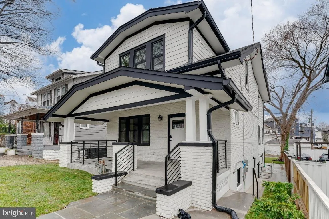Renovated Woodridge bungalow with white painted brick, black trim and a wide front porch