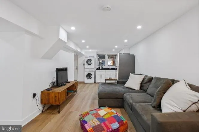 In-law suite lounge with wide-plank flooring, a kitchenette and full-size refrigerator